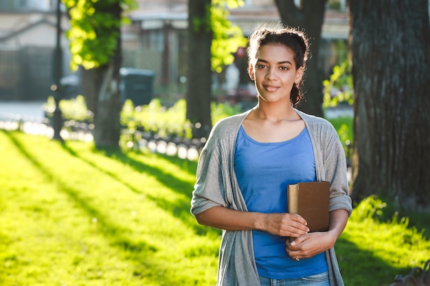 Bella ragazza africana allegra che legge il libro