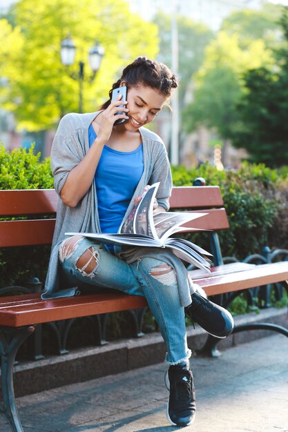 Bella ragazza africana Thouhtful che legge il libro