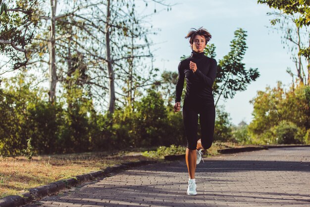 Bella ragazza che corre nel parco.