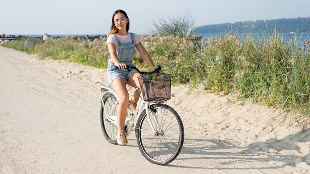 Bella ragazza che guida la bici all'aperto