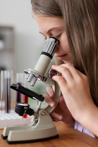 Bella ragazza che impara di più sulla chimica in classe