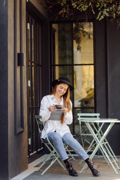 Bella ragazza che mangia caffè al caffè