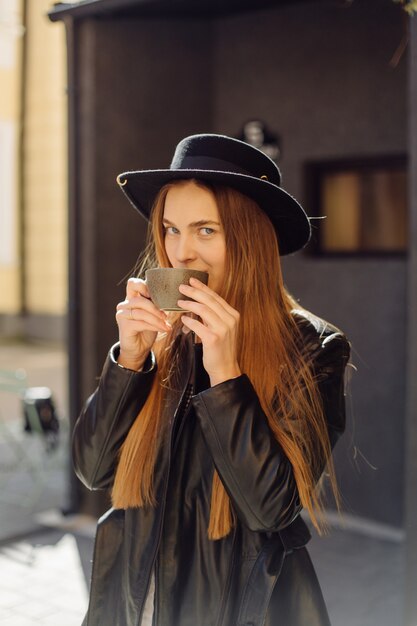 Bella ragazza che mangia caffè al caffè