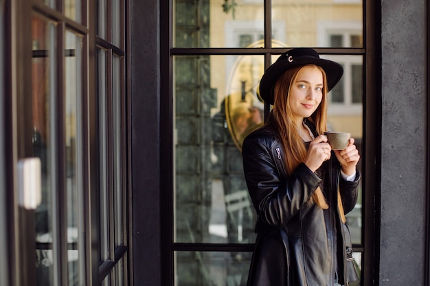 Bella ragazza che mangia caffè al caffè