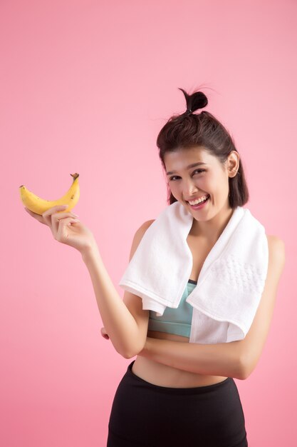 Bella ragazza che mangia le banane dopo l&#39;esercizio per controllare il peso