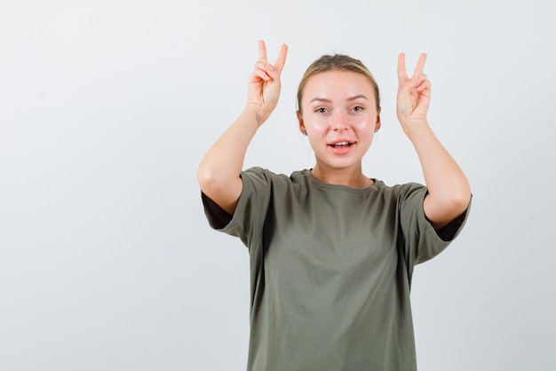 bella ragazza che mostra le corna su sfondo bianco