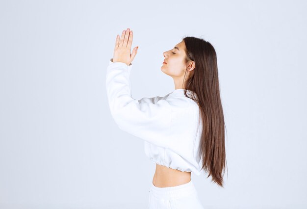 bella ragazza che prega con le mani insieme.