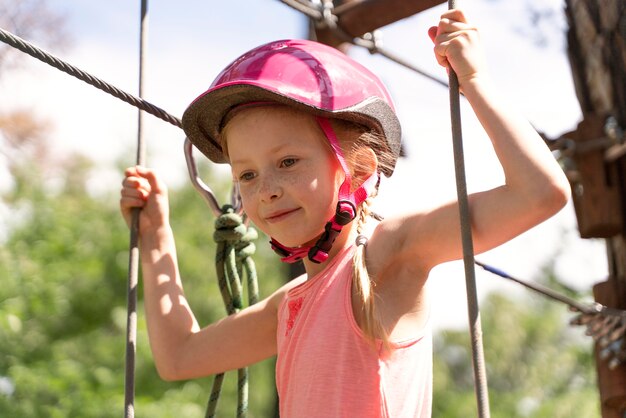 Bella ragazza che si diverte in un parco avventura