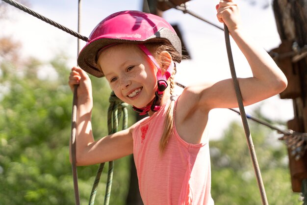 Bella ragazza che si diverte in un parco avventura