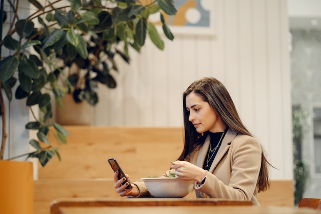 Bella ragazza che si siede in un caffè