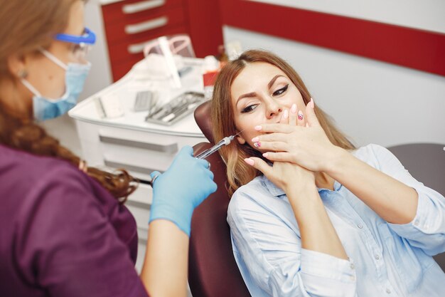 Bella ragazza che si siede nell'ufficio del dentista