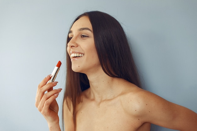 Bella ragazza che sta con il rossetto rosso