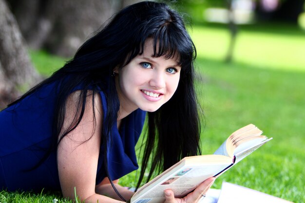 Bella ragazza che studia nel parco