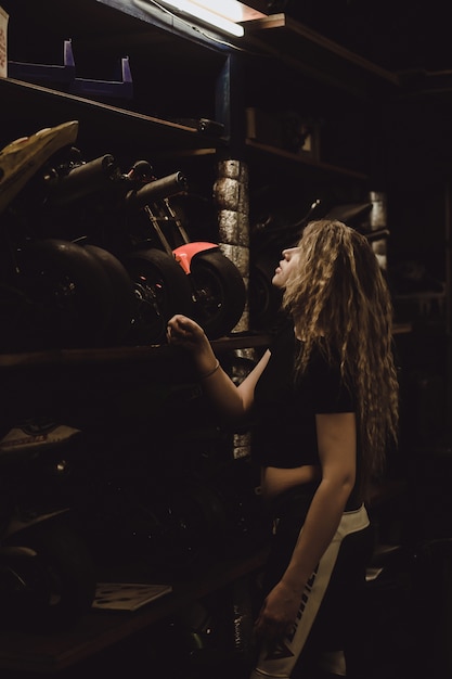 bella ragazza con i capelli lunghi nel garage di riparare una moto