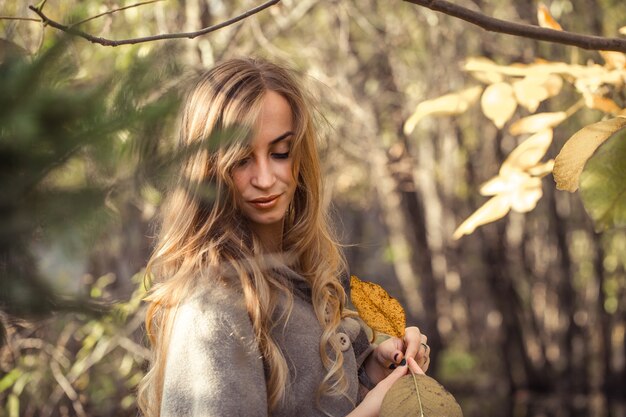 bella ragazza con i capelli lunghi nella foresta di autunno, concetto di stagione autunnale