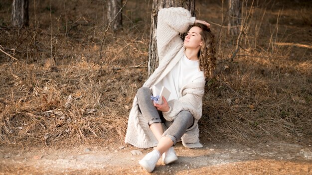 Bella ragazza con i capelli ricci nel bosco