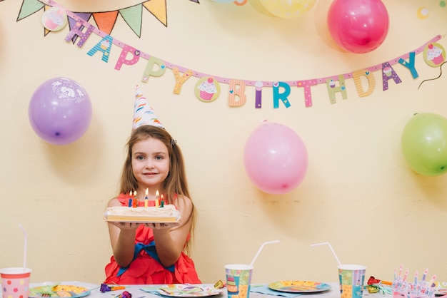 Bella ragazza con torta di compleanno