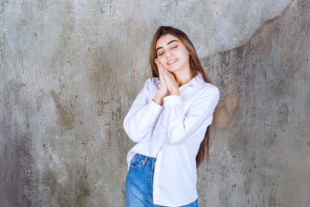 Bella ragazza dai capelli lunghi in camicetta bianca in piedi e dorme