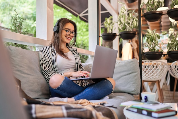 Bella ragazza dello studente che impara a casa con il computer portatile.