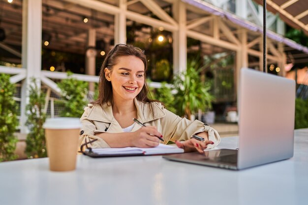 Bella ragazza dello studente che impara online all'aperto.