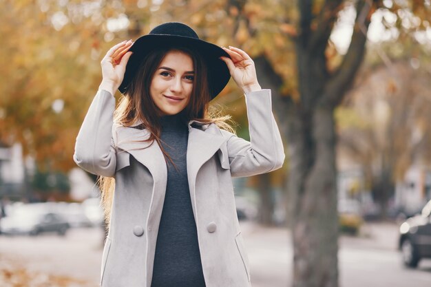 bella ragazza elegante che cammina intorno alla città di autunno