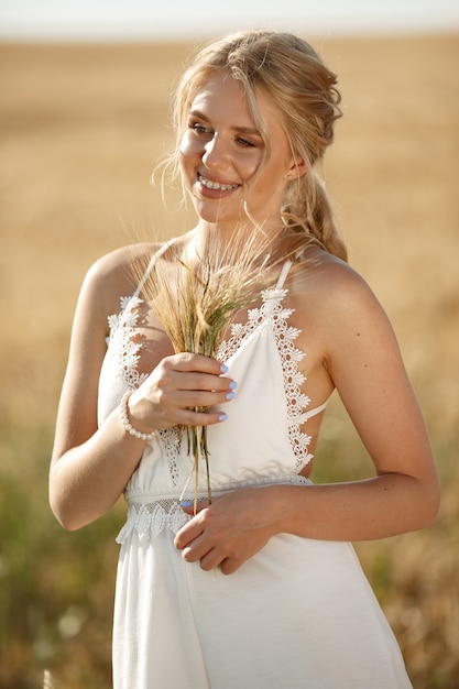 Bella ragazza elegante in un campo autunnale