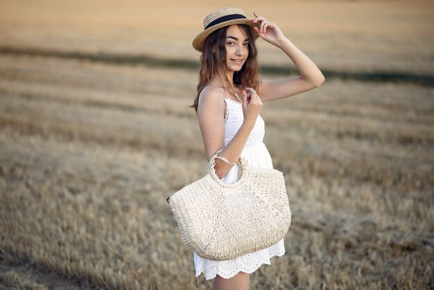 Bella ragazza elegante in un campo di grano in autunno