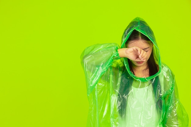 bella ragazza felice, con indosso abiti verdi, ombrello e cappotto, giornata di pioggia.