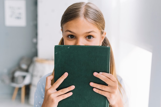 Bella ragazza felice in posa con un libro