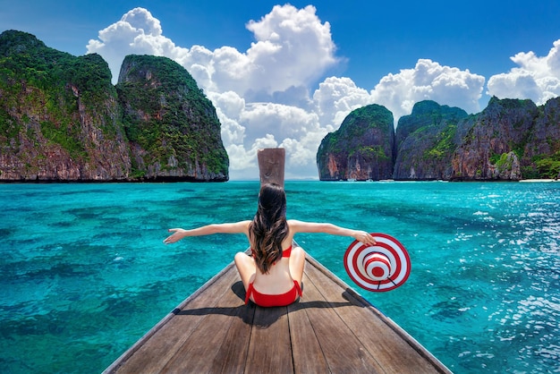 Bella ragazza in bikini rosso sulla barca all'isola Thailandia di Koh Phi phi