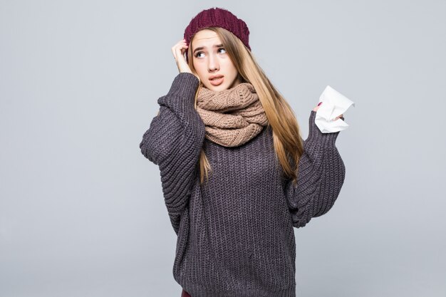 Bella ragazza in maglione grigio ha freddo ha avuto mal di testa influenzale su grigio