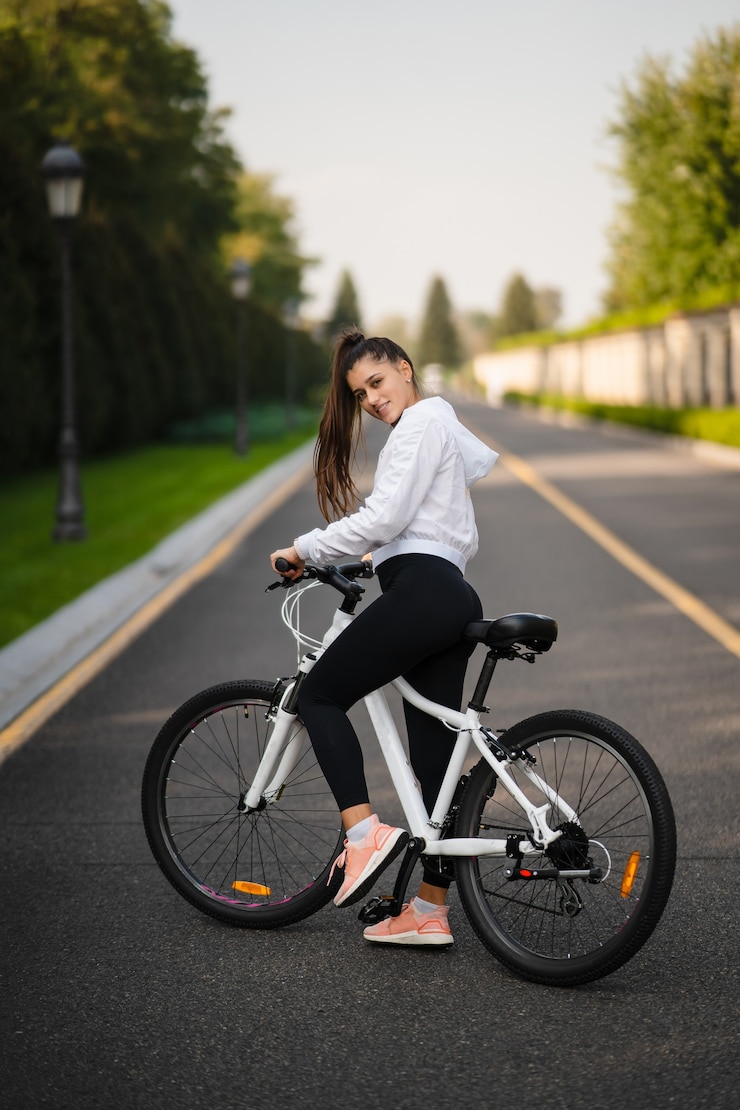 Foto gratuito bella ragazza in posa in bicicletta bianca. cammina nella natura. uno stile di vita sano.