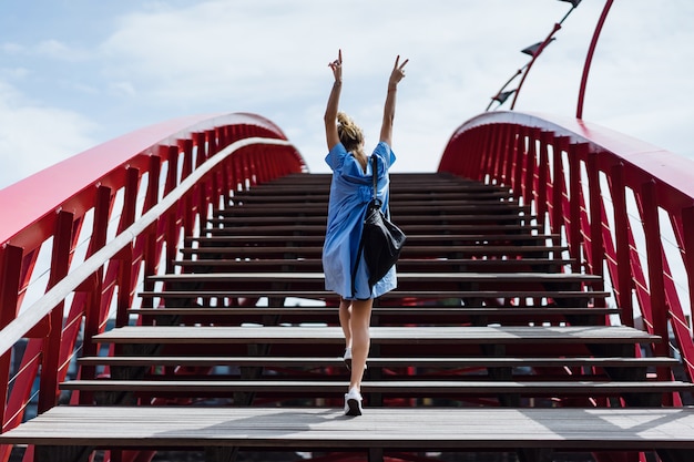 bella ragazza in un abito blu in posa sul ponte