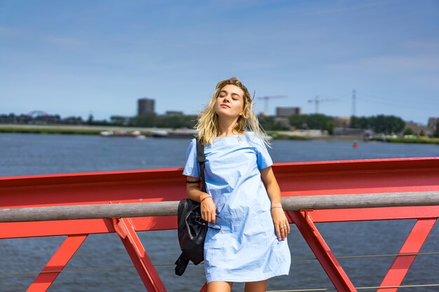 bella ragazza in un abito blu in posa sul ponte