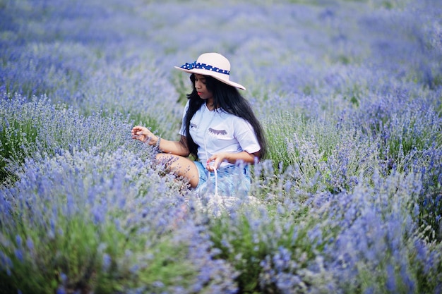 Bella ragazza indiana tenere cestino nel campo di lavanda viola