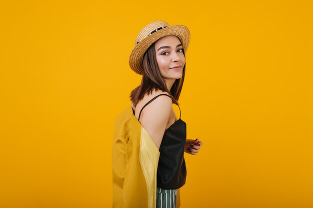 bella ragazza mora indossa cappello di paglia. Ritratto dell'interno della magnifica signora isolata.