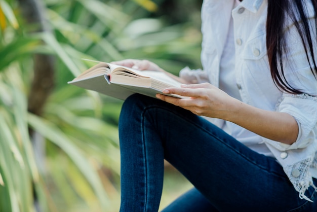 Bella ragazza nella foresta di autunno leggendo un libro