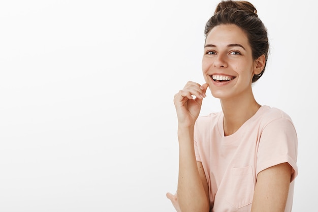 Bella ragazza romantica che posa contro il muro bianco