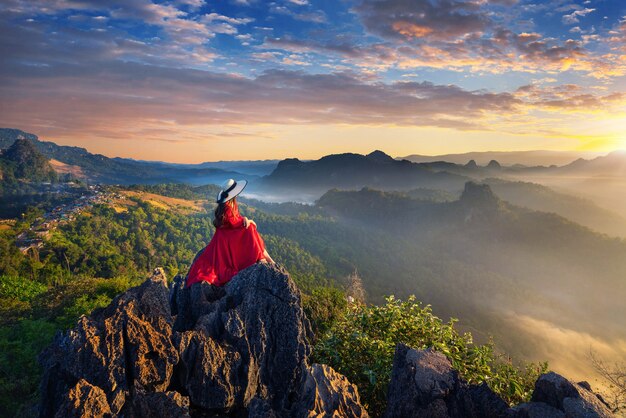 Bella ragazza seduta sul punto di vista di alba al villaggio di Ja Bo, provincia di Mae hong son, Thailandia