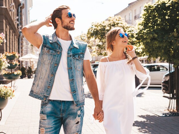 Bella ragazza sorridente e il suo ragazzo bello che camminano nella strada.