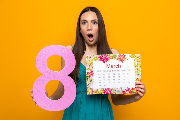 Bella ragazza spaventata il giorno della donna felice che tiene il calendario con il numero otto