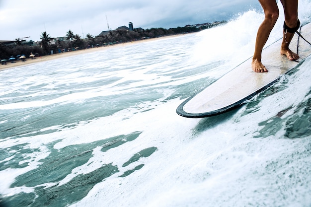 bella ragazza surfista in sella a una tavola