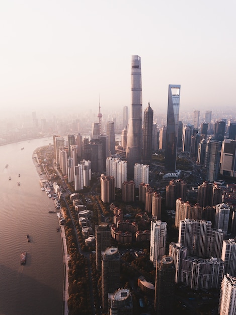 Bella ripresa dall'alto dello skyline della città di Shanghai con alti grattacieli e un fiume sul lato