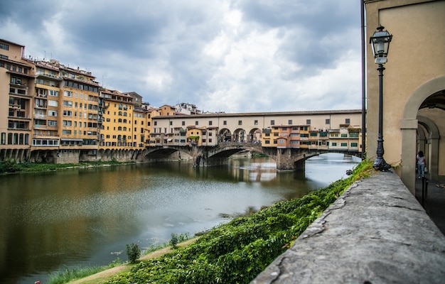 Bella ripresa del Ponte Vecchio a Firenze, Italia con un cielo grigio nuvoloso in background