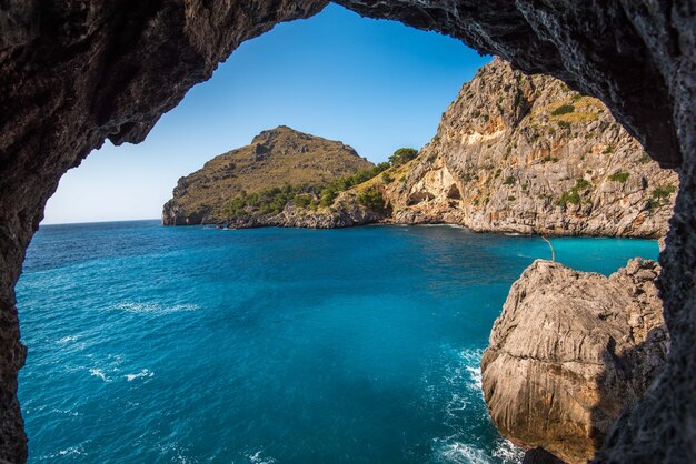 Bella ripresa delle scogliere vicino all'oceano attraverso l'arco in pietra naturale