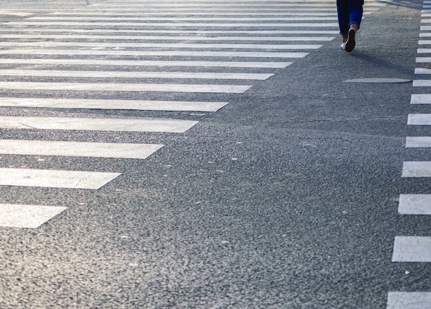 Bella ripresa delle strisce pedonali sulla strada con la donna che ci cammina sopra