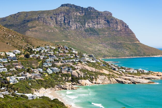 Bella ripresa di edifici su una collina in spiaggia turchese a Cape Town, Sud Africa