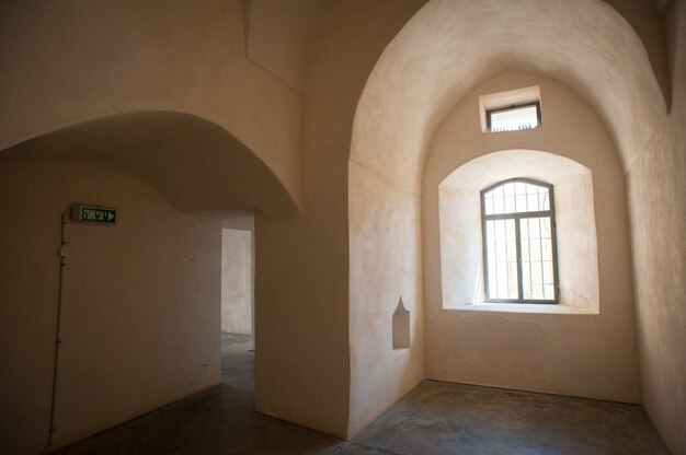 Bella ripresa di un interno di un edificio vuoto con pareti beige di finestre e un segnale di uscita