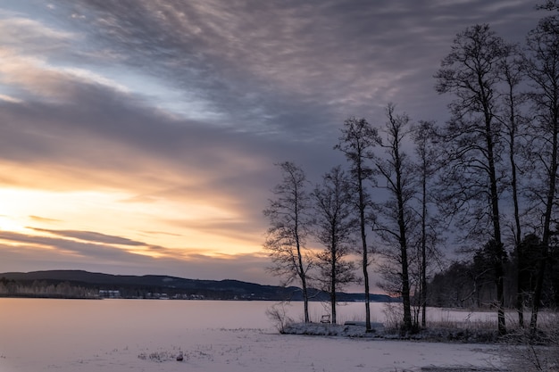 Bella ripresa di un lago ghiacciato con uno scenario di tramonto nel cielo