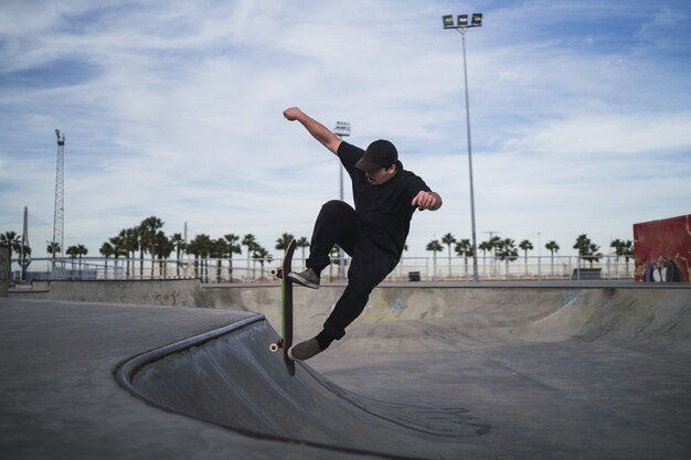 Bella ripresa di un uomo che fa skateboard in uno skatepark durante il giorno